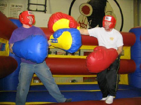 Participants wearing oversized boxing gloves inside the Inflatable Boxing ring